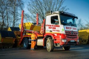 Lytham St Annes Skip Hire lorry with skips and a team member in a yard